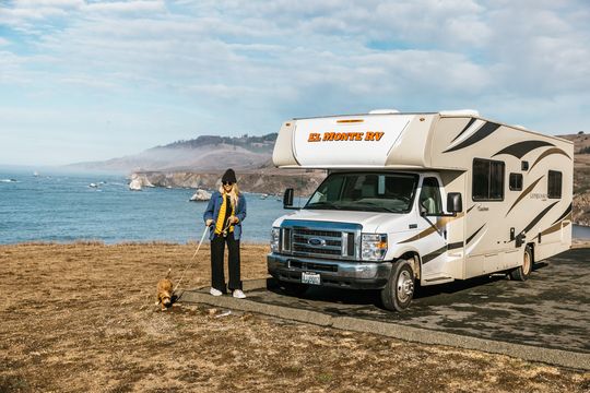 girl-dog-walking-parked-rv-ocean_Amerika_camperreizen_DoetsReizen