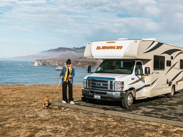 girl-dog-walking-parked-rv-ocean_Amerika_camperreizen_DoetsReizen